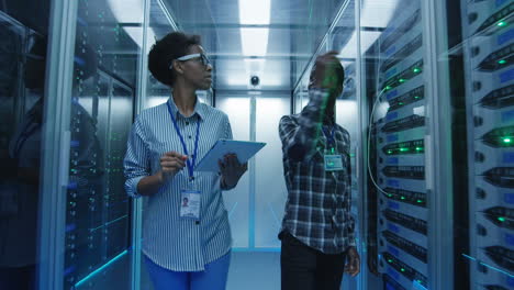 it professionals working and inspecting servers in a data center