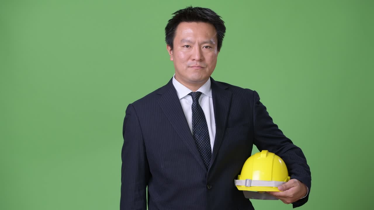 녹색 배경에 성숙한 일본 사업가