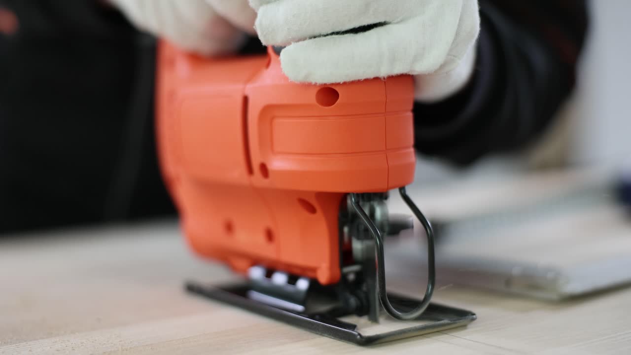 Close-up of a person using a jigsaw for woodworking