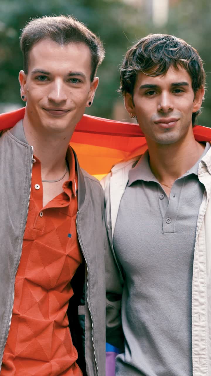 Two men holding a rainbow flag in support of LGBTQ pride