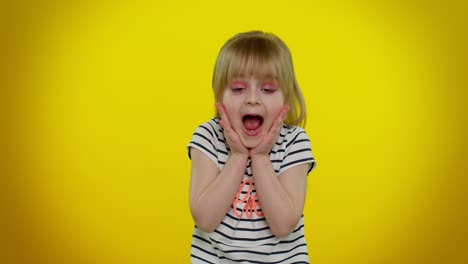excited amazed child girl raising hands in surprise looking at camera with big eyes, wow victory