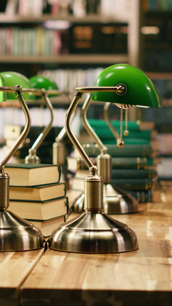 Vertical Video Empty university library with a stack of books and green lamp at desk