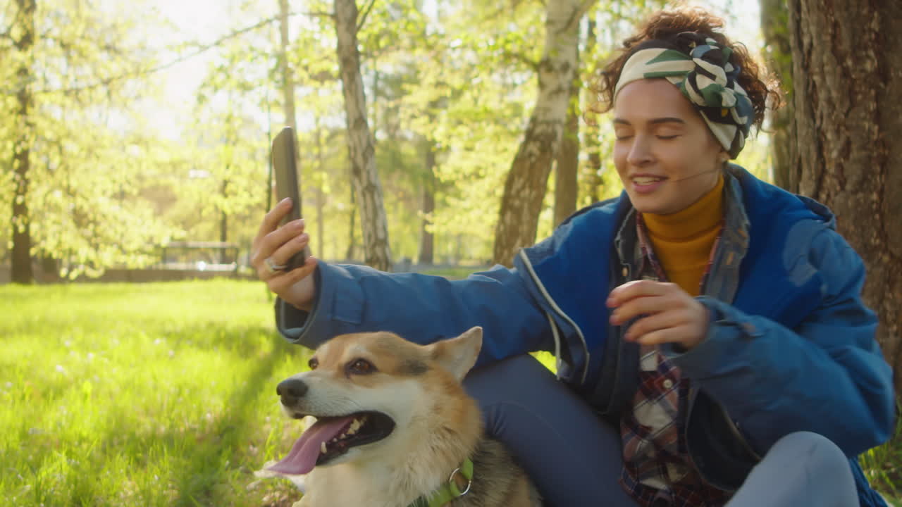 Woman Taking Selfie with Corgi Dog in Park