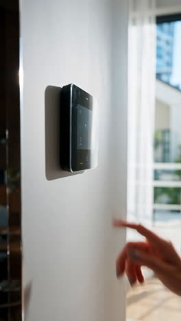 person interacting with a smart home control panel