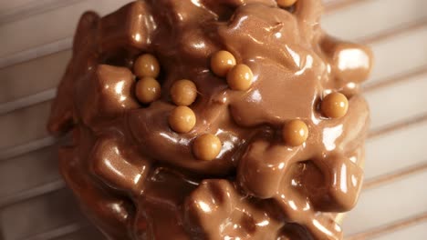 chocolate ferrero donut being covered with caramel pieces