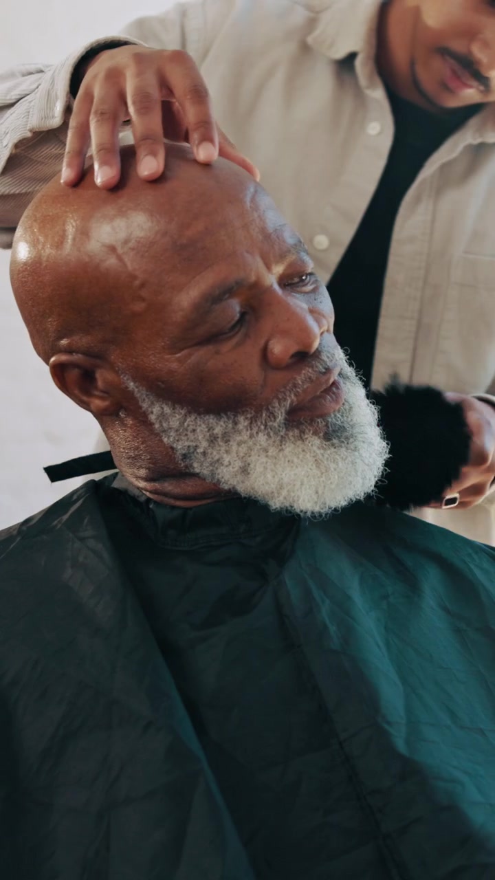 Barber Brushing Hair and Beard of Senior Man in Salon