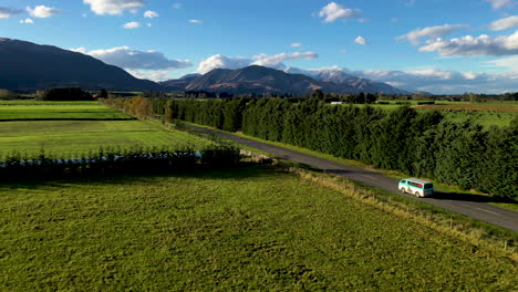 rising drone shot van driving in country towards mountains new zealand