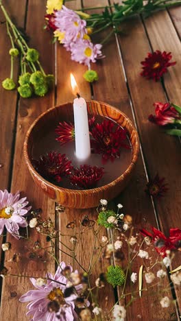 candle and flowers arrangement on wooden table