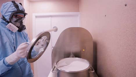 scientist operating laboratory equipment in a clean room