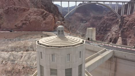 aerial view of the hoover dam and an intake tower with cars doing over the dam