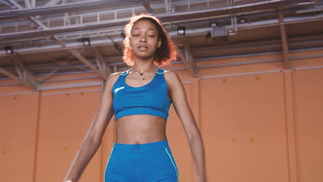 young sportswoman warming up and stretching her body in an indoor sport facility