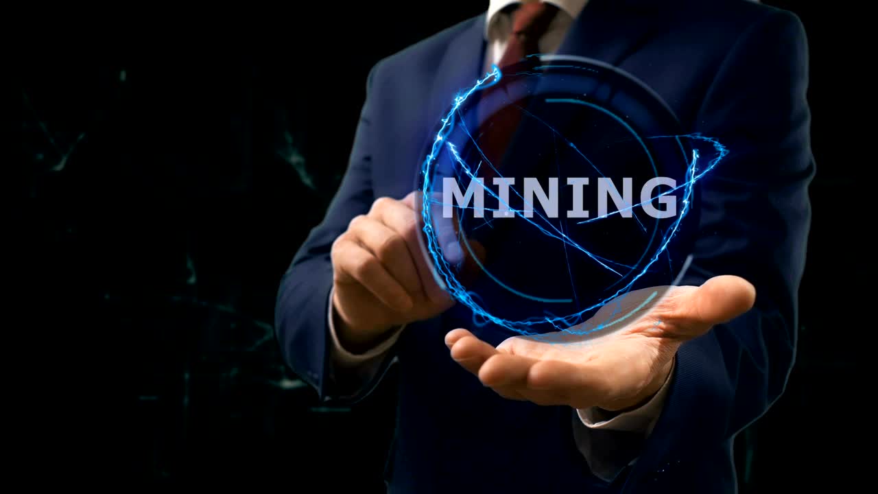 Businessman shows concept hologram Mining on his hand