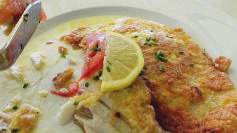primer plano de comer pescado blanco frito en una delicada cáscara de huevo