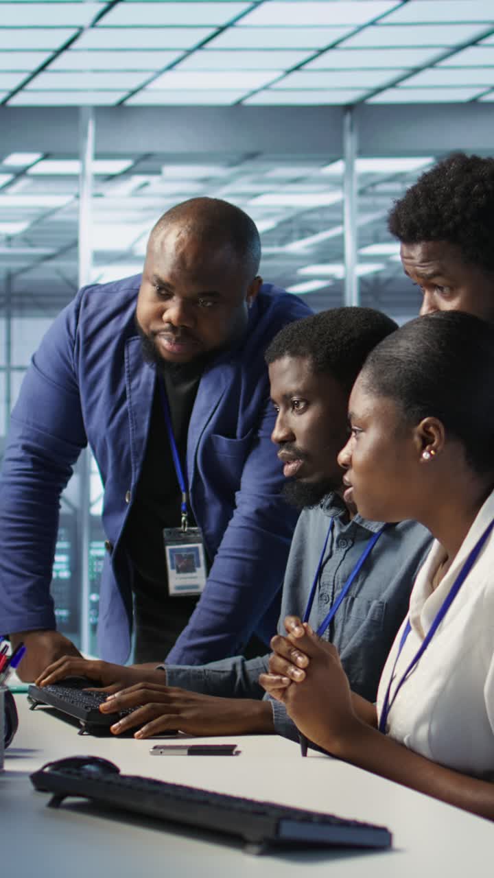Vertical video Teamworking engineers talking in server room, doing brainstorming