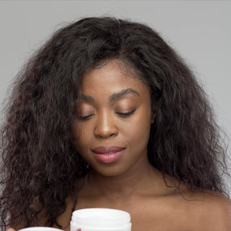 Black-woman-smelling-cream-with-closed-eyes