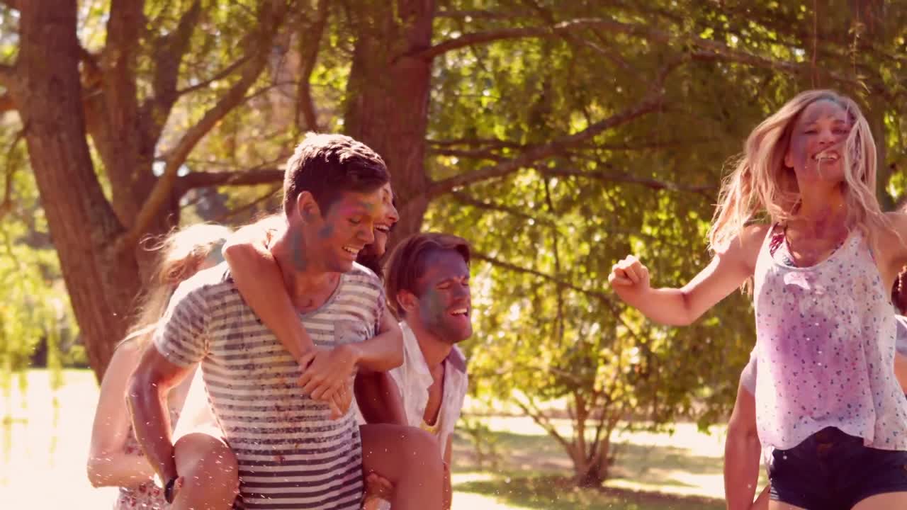 amigos jóvenes divirtiéndose con la manguera en el parque