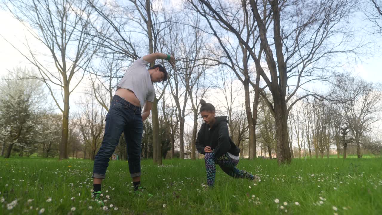 una pareja estirándose en un parque.