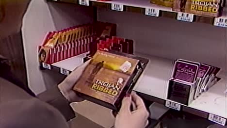 mujer de la década de 1980 mira una caja de condones en el estante