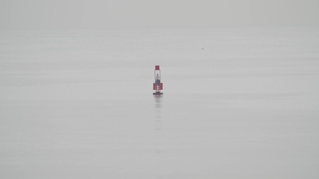 느린 동작 60fps로 흐린 날 잔잔한 바다에 떠 있는 낚시 부표
