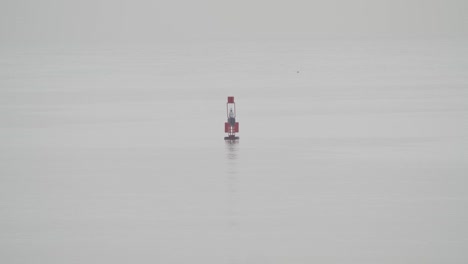 fishing buoy floating in calm sea in a cloudy day in slow motion 60fps