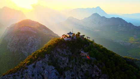 video aéreo 4k de un drone de una estación de cable de tunektepe teleferik posicionada en la cima de la colina con las montañas en el fondo
