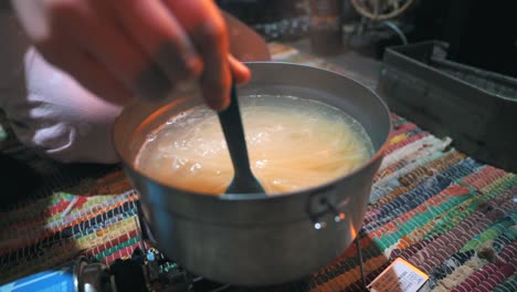 Cocinar-Pasta-Con-Una-Estufa-De-Gas-Portátil-En-Una-Cabaña-En-La-Naturaleza,-Al-Aire-Libre,-Acampar