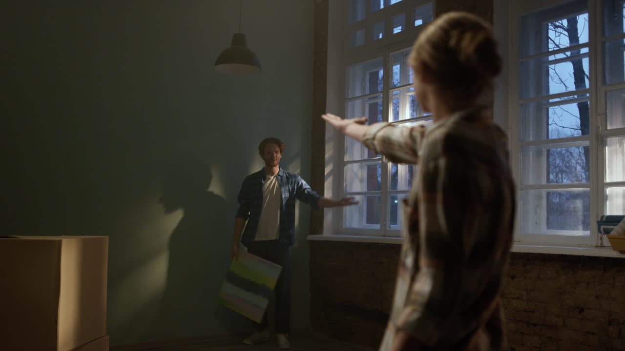 새로운 집을 장식하는 즐거운 가족. 여성과 남자가 인테리어를 장식하려고합니다.