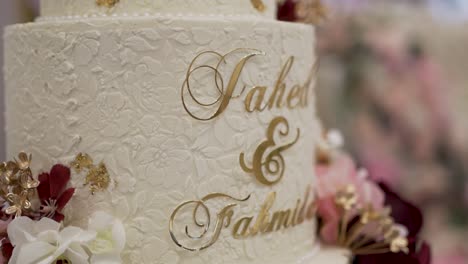 the wedding cake in the venue hall is beautifully decorated and showcased in a close-up view.