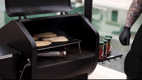 Man-moves-smoked-fish-from-the-grill-to-the-cutting-board