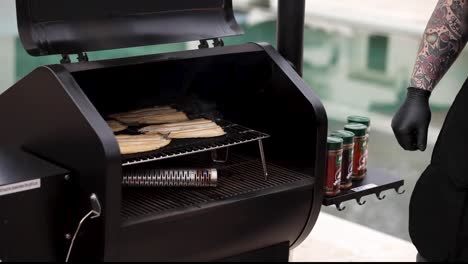 man moves smoked fish from the grill to the cutting board