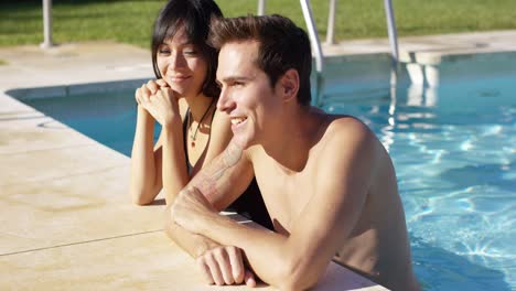 Diverse-good-looking-couple-stand-in-swimming-pool