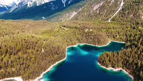 amazing turquoise lake in the mountains in europe. thick evergreen forests cover the picturesque rocks. aerial view.