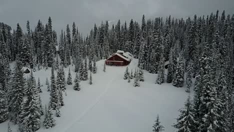 flying low and approaching remote cabin in the woods in winter