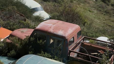 vista de un camión rojo vintage en un depósito de chatarra de automóviles