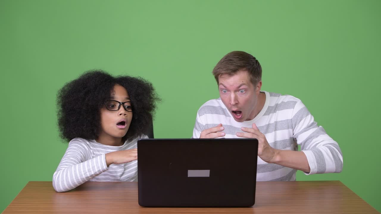 una joven africana y un joven escandinavo usando una computadora portátil juntos