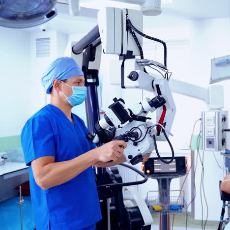 patient lying on operating table. group of medical specialists in the operating room. surgeon prepares special equipment before the operation.