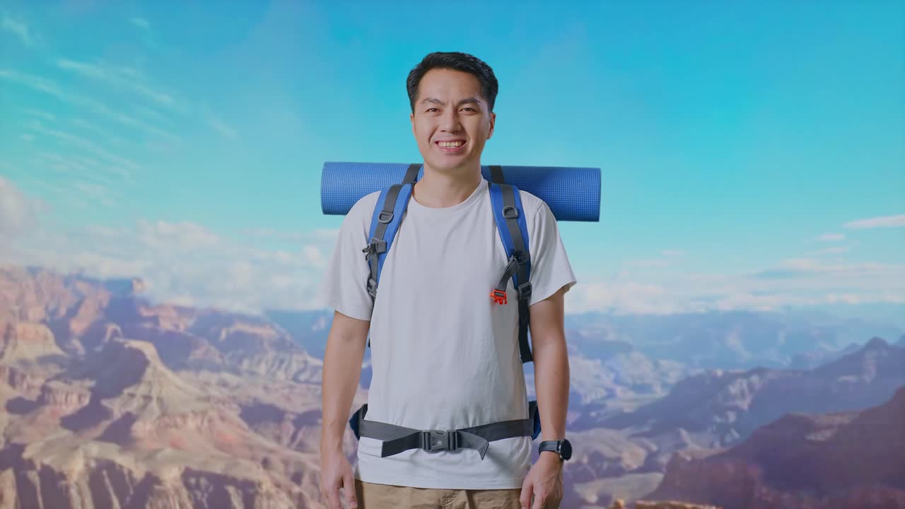 Asian Male Hiker With Mountaineering Backpack Smiling To Camera While Traveling At The Top Of Mountain
