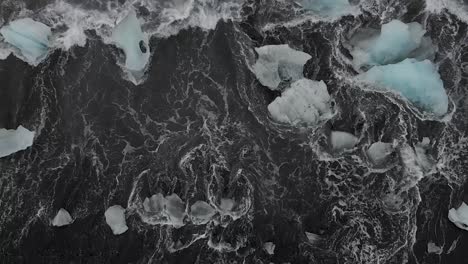 slow motion shot from above icebergs on black sand beach