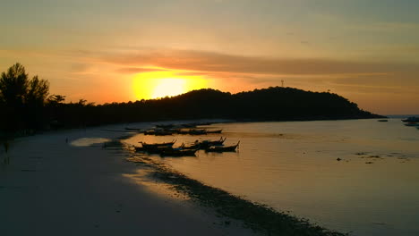 Toma-Aérea-De-La-Playa-Durante-La-Puesta-De-Sol-Con-Un-Barco-Tailandés