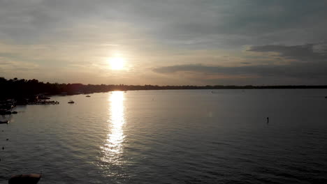 Lago-Disparado-Por-Drones-Al-Atardecer-Con-Barcos-Que-Avanzan