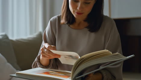 woman browsing through a book at home