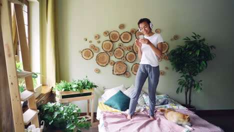 woman listening to music and using phone in bedroom