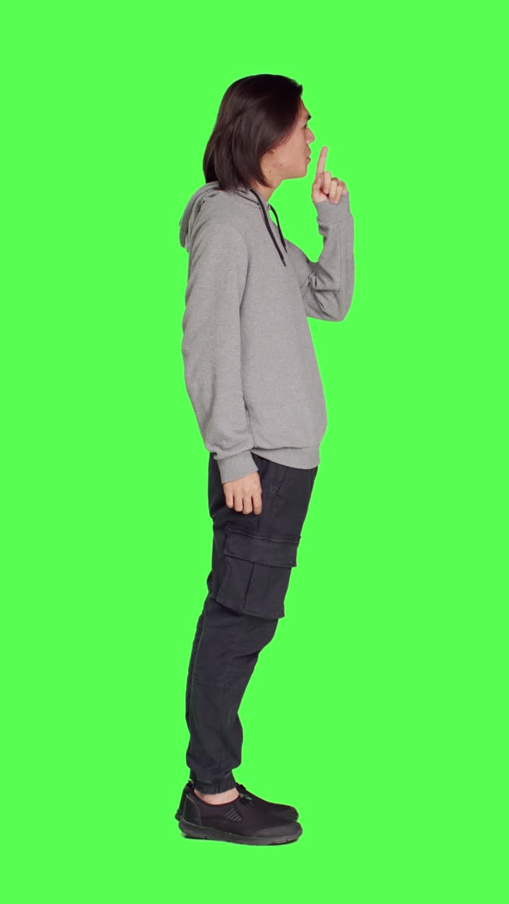 Profilo di adulto che fa il gesto del silenzio su greenscreen