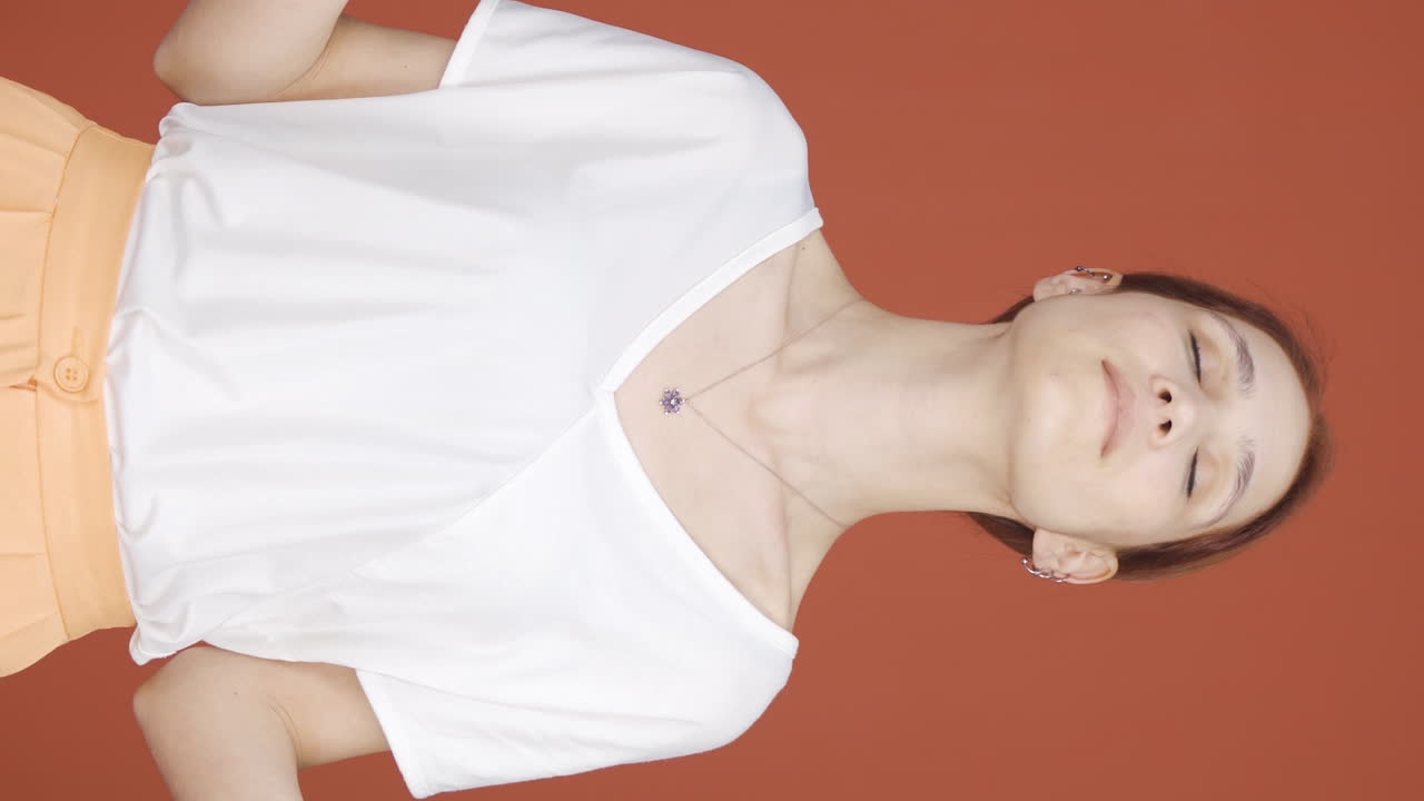 카메라를 바라보며 명상하는 여성의 수직 비디오.