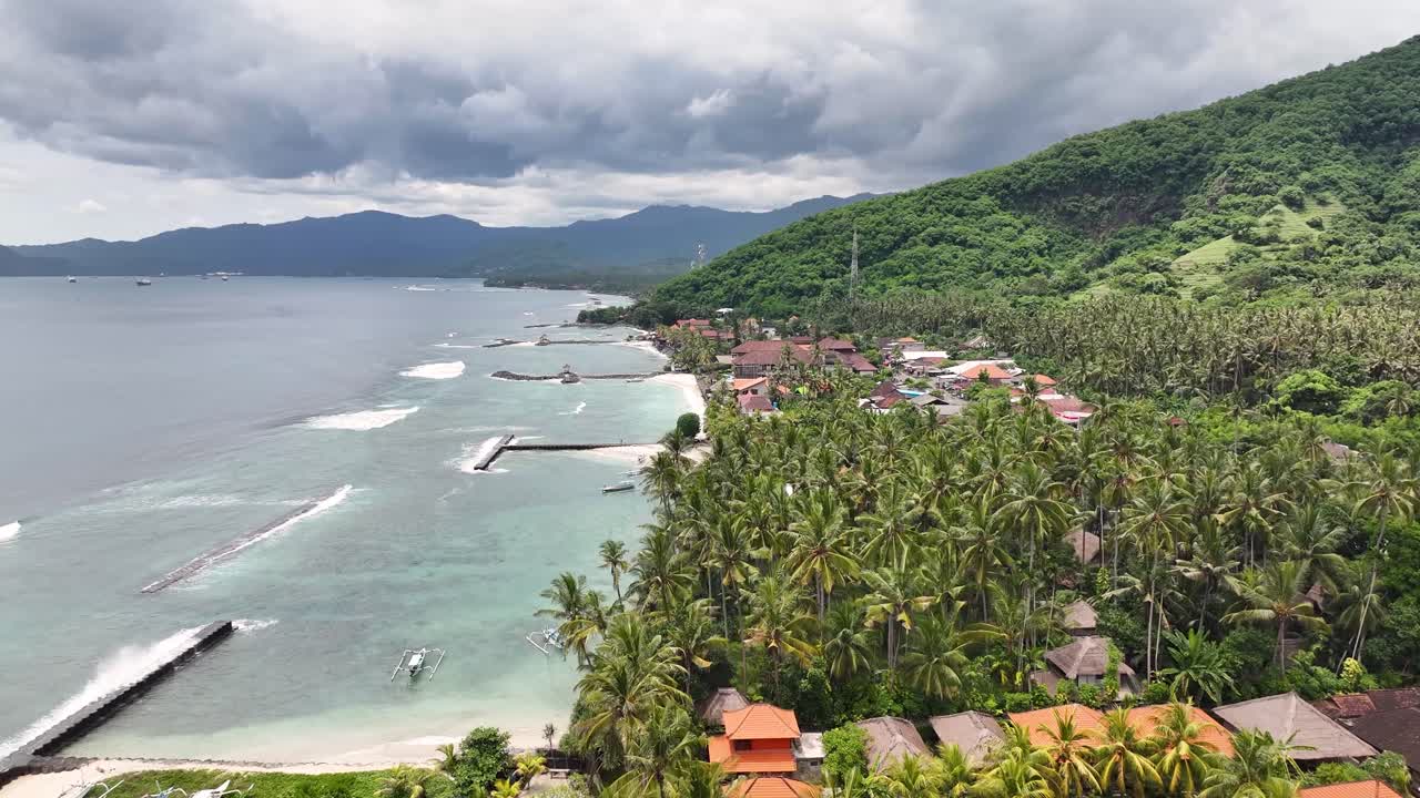 Drone flyover palm trees and hotel on Candidasa Beach in Bali, Indonesia. Travel destination