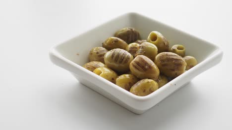 green olives in a small white bowl