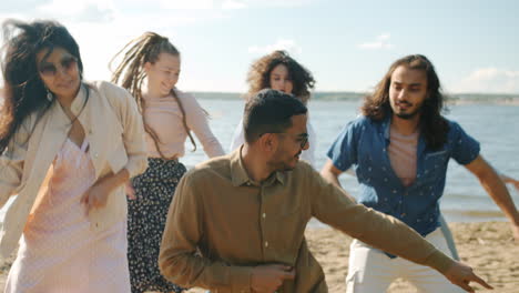 amigos bailando en la playa.