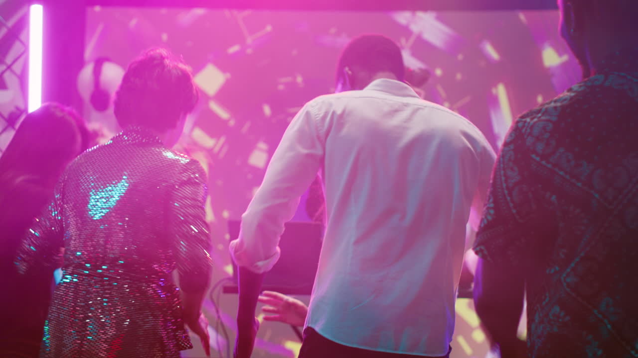 DJ müziği ve renkli ışıklarla bir gece kulübü partisinde dans eden insanlar