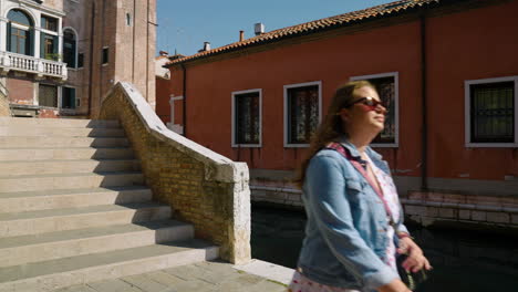 tourist girl in white dress walking through streets of venice in italy - approach