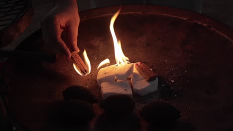 close up of person lighting a flame on a grill at a campsite